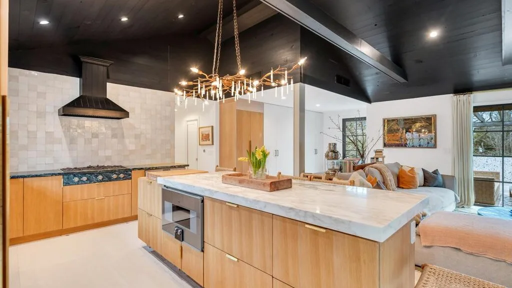 An open-plan kitchen and living area with a large central island and seating.