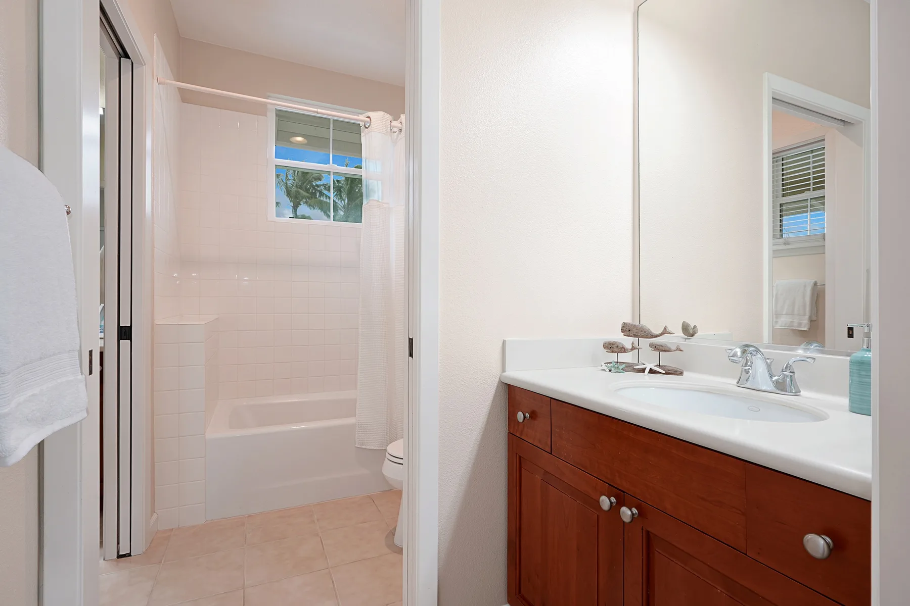 Un baño luminoso con bañera y un tocador de madera.