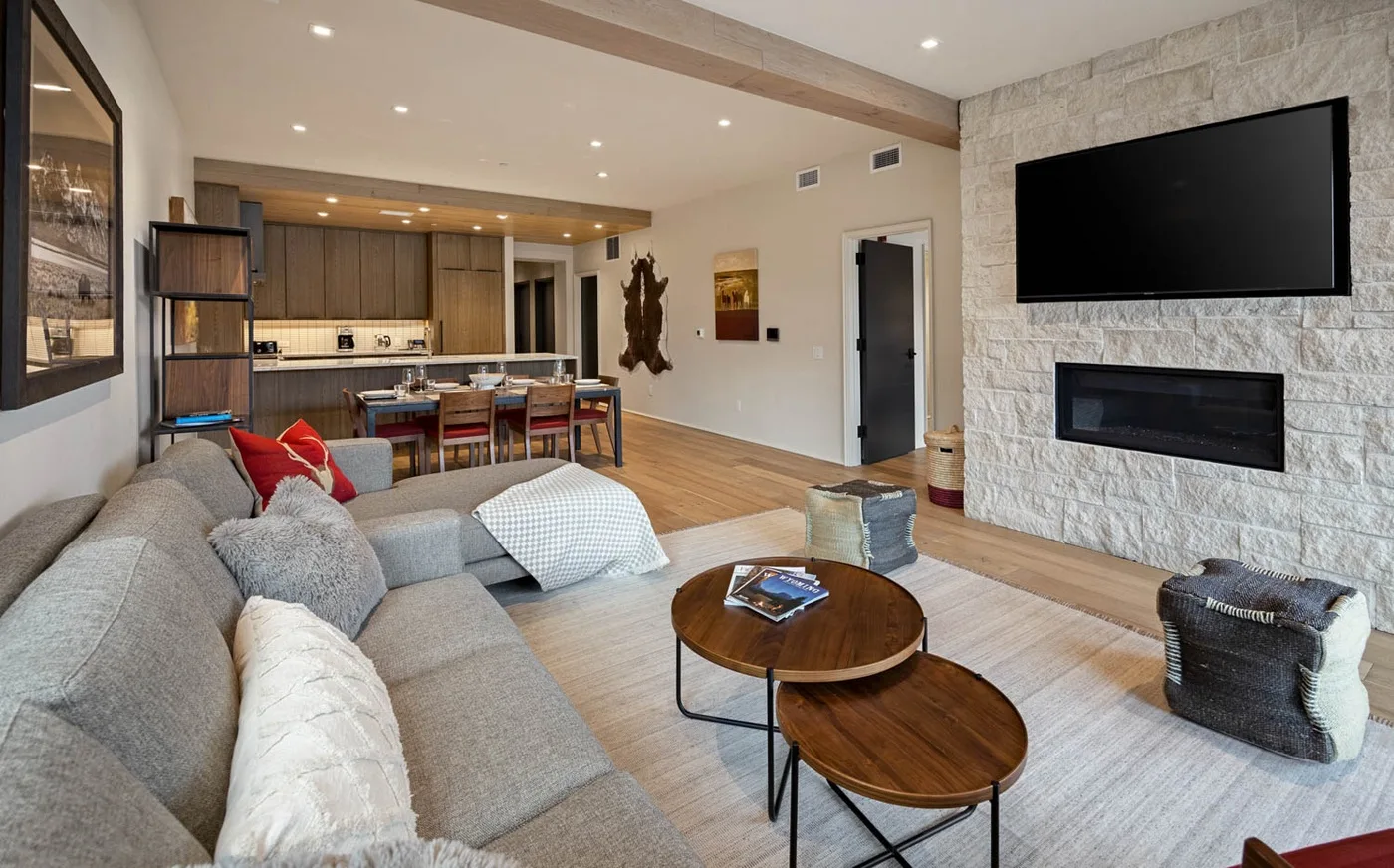 An open-plan living room with a sectional seating area and kitchen island.