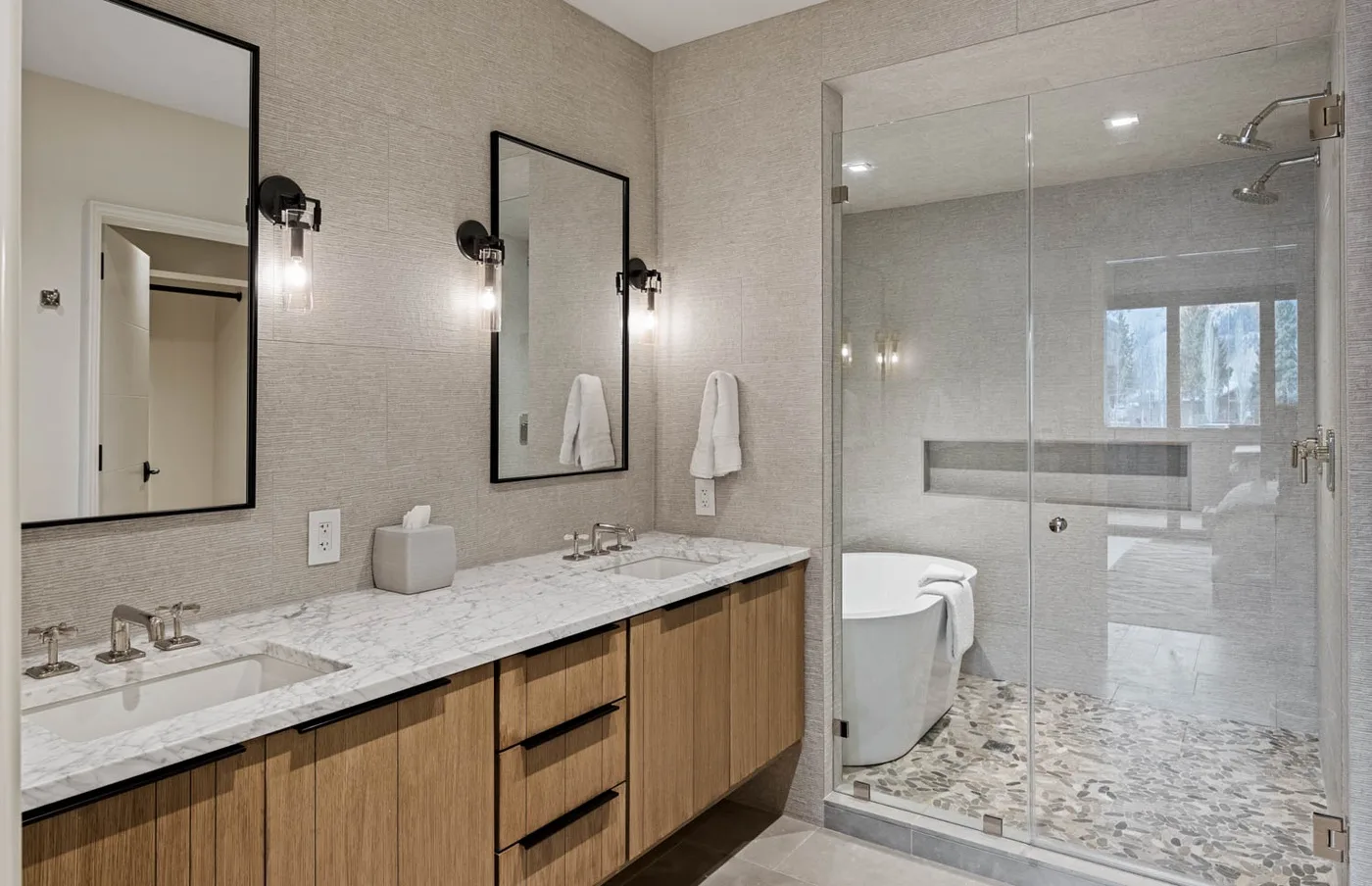 A modern bathroom with a double vanity and a glass-enclosed shower.