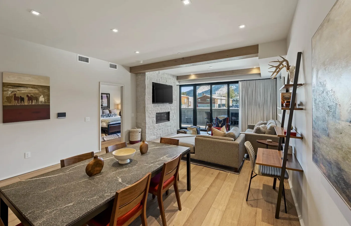 A living room and dining area with large windows and contemporary seating.