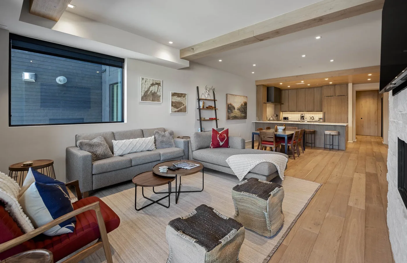 A living room with a sectional seating area beside an open kitchen.