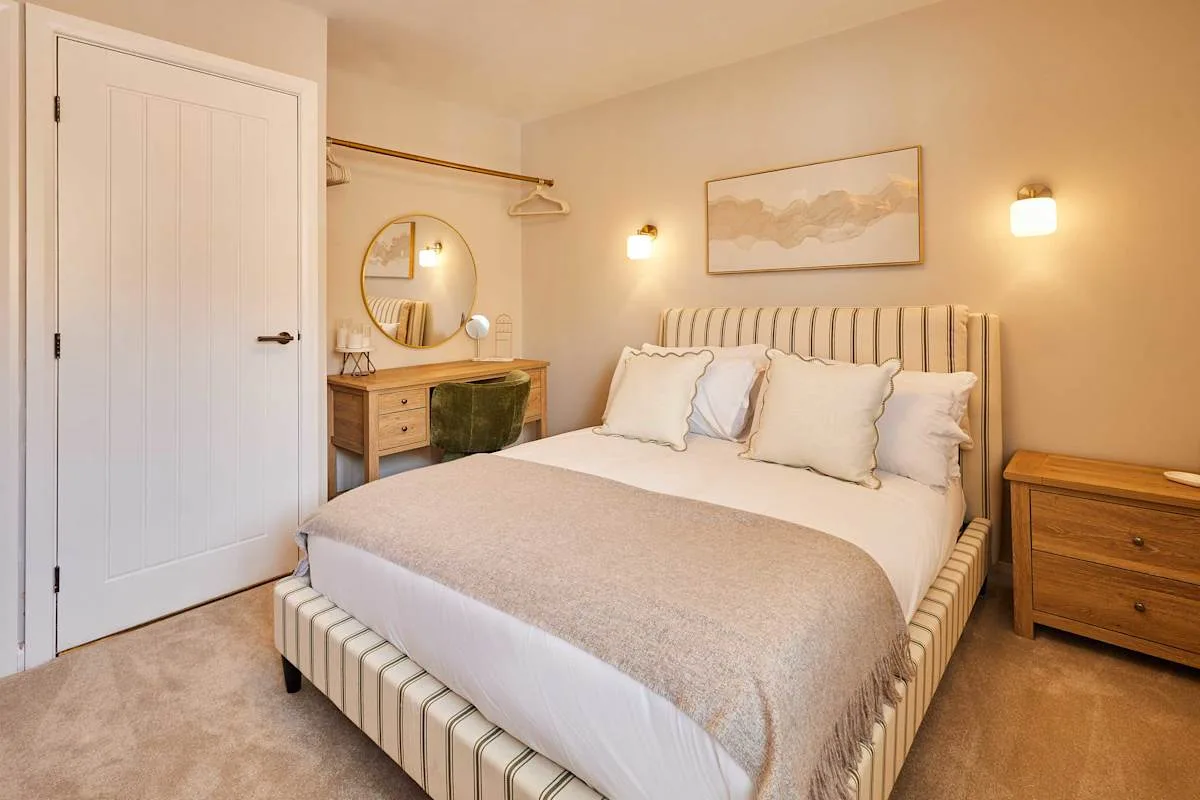 A bedroom with a neatly made bed and matching bedside tables.