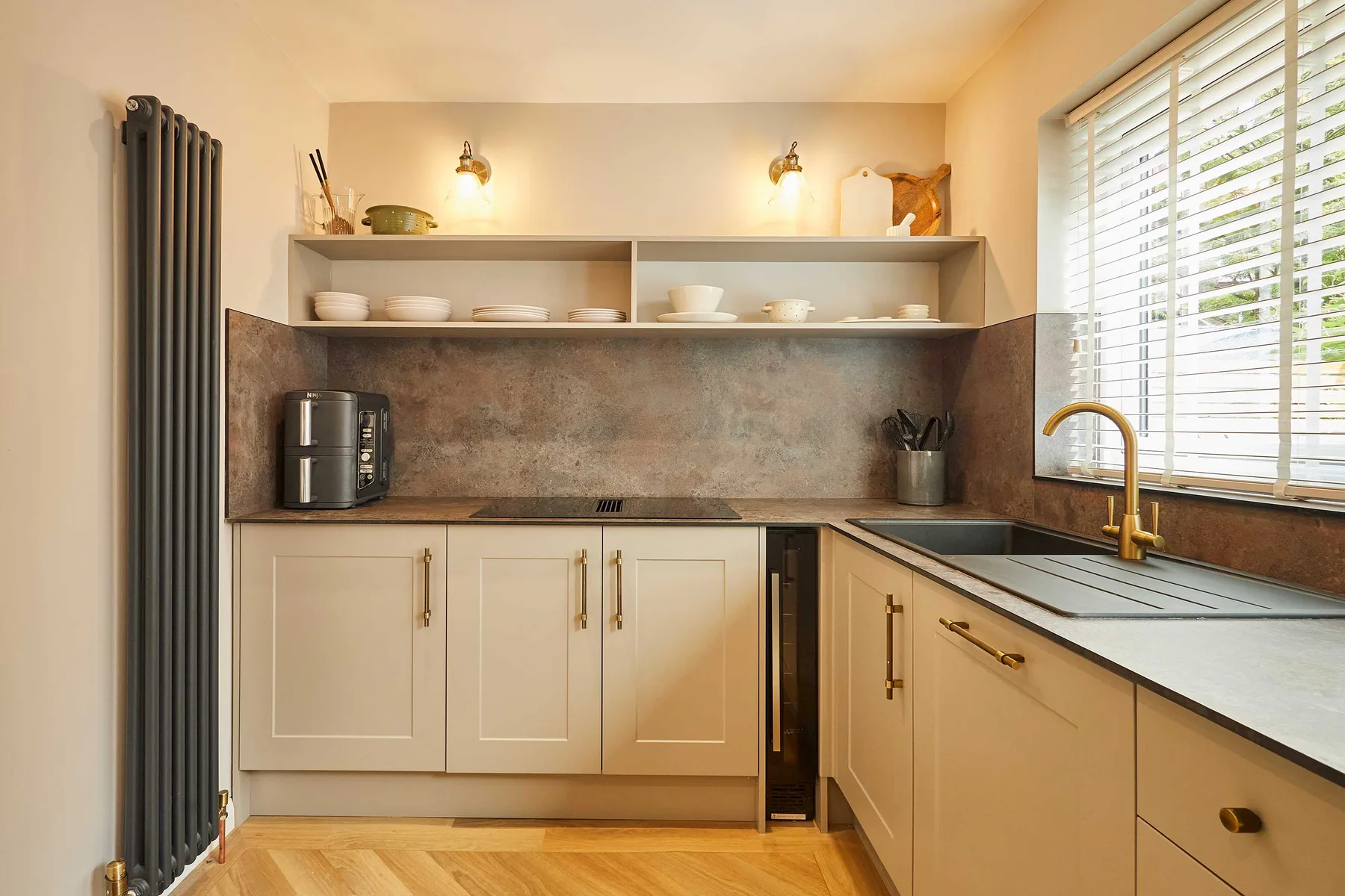 A bright kitchen with open shelving and a window above the counter.