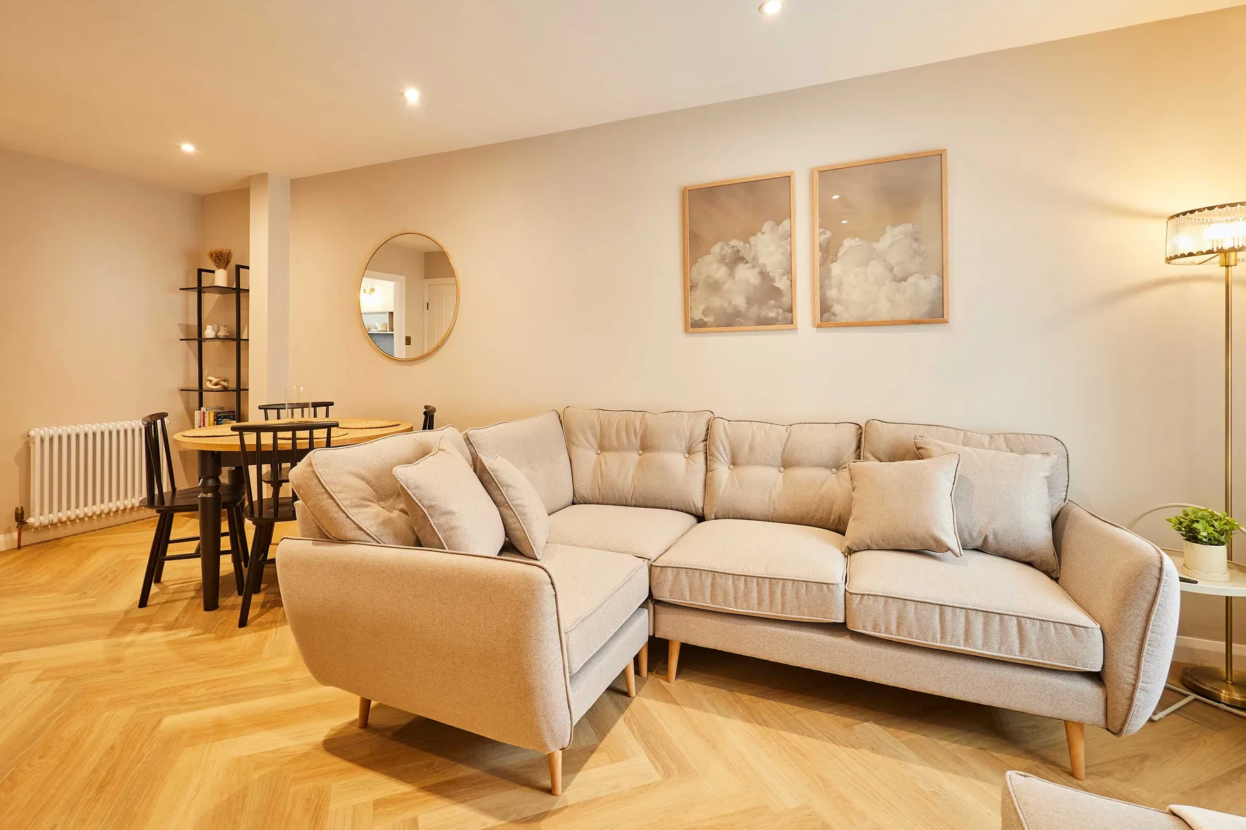 A bright living room with beige seating and a dining table.
