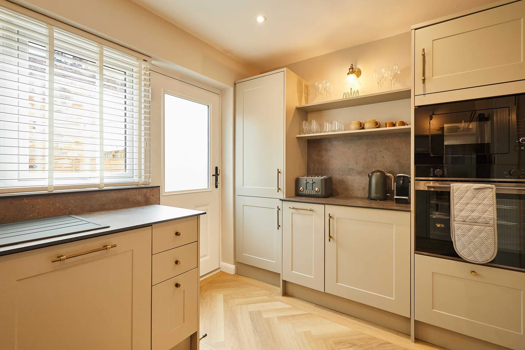 A bright kitchen with pale cabinetry, a countertop, and built-in appliances.