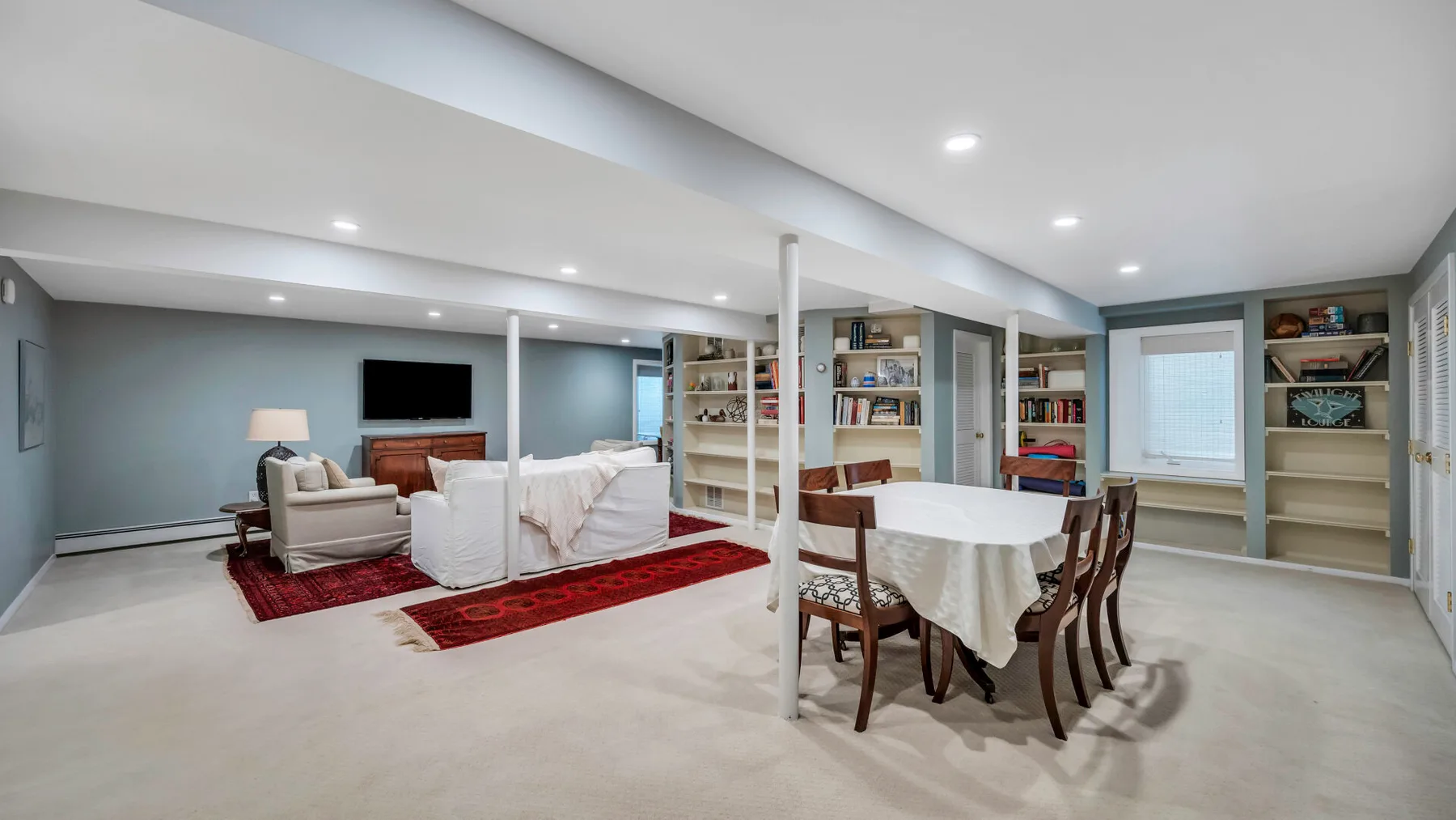 An open living and dining area with seating, a table, and built-in shelving.