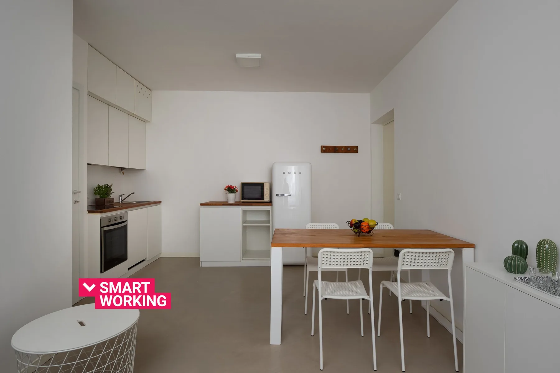 A bright kitchen and dining area with a table, chairs, and white cabinetry.