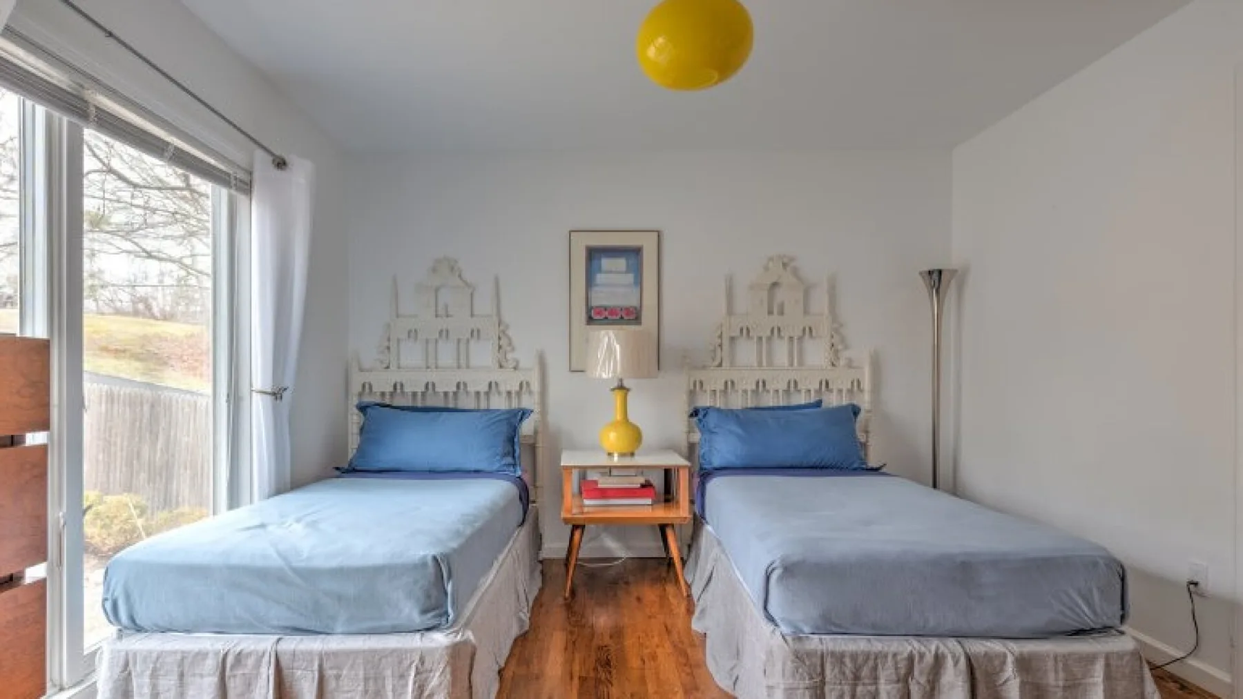 Un dormitorio con dos camas individuales y una mesita entre ellas.