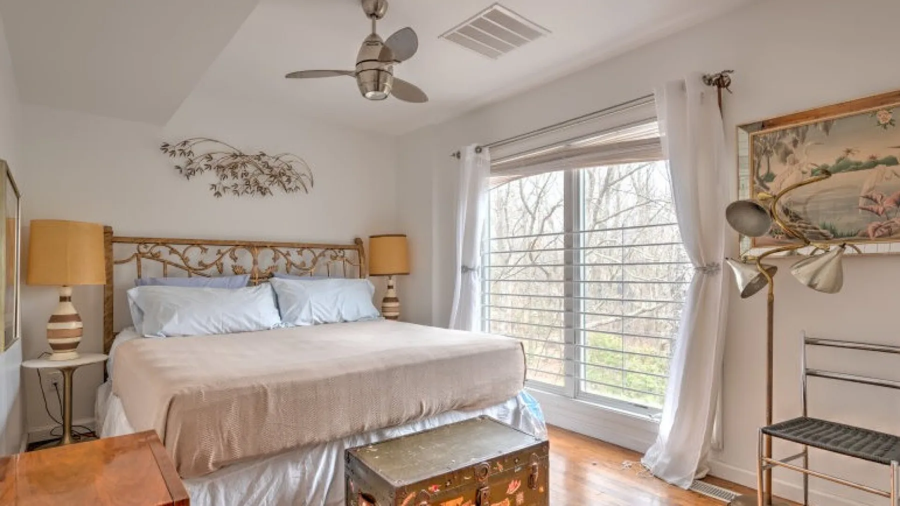 Un dormitorio con una cama junto a una ventana grande.