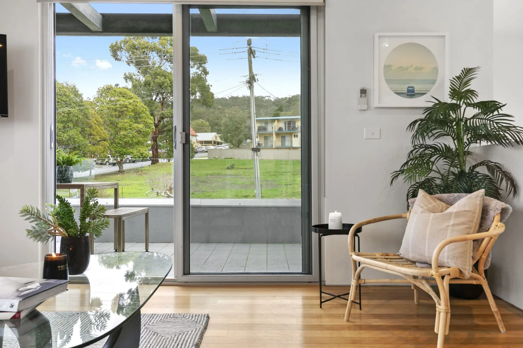 Una sala luminosa con una puerta de vidrio y vistas a un espacio verde exterior.