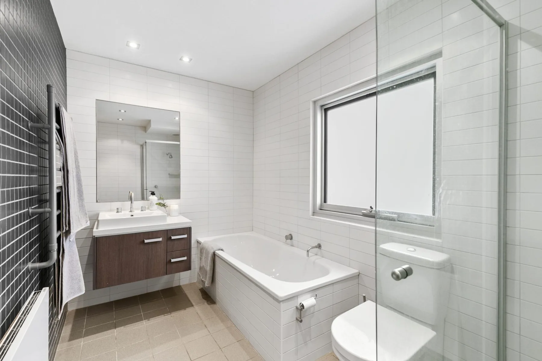 Un baño con azulejos, bañera, lavabo e inodoro.