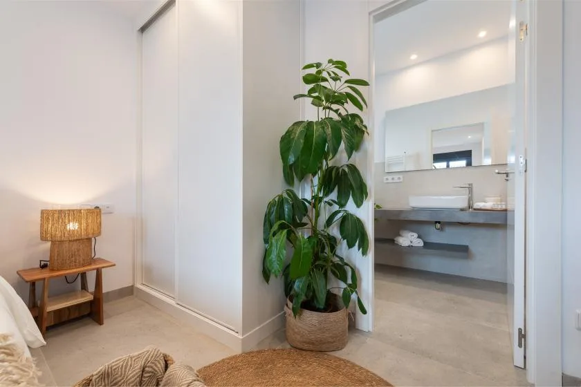 Una zona de estar del dormitorio da a un baño abierto con lavabo y espejo.