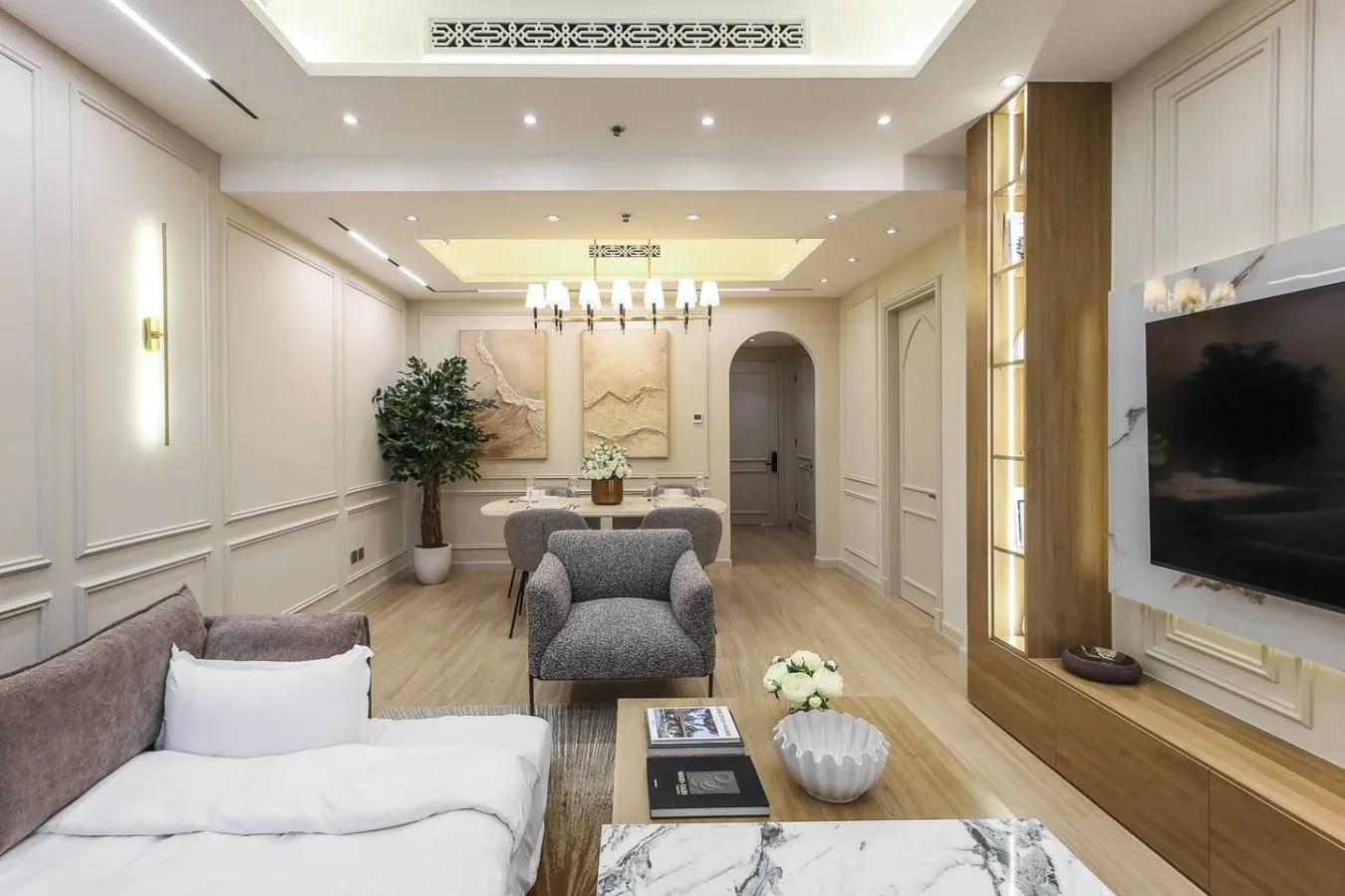 Una sala luminosa con asientos, un televisor y un comedor.