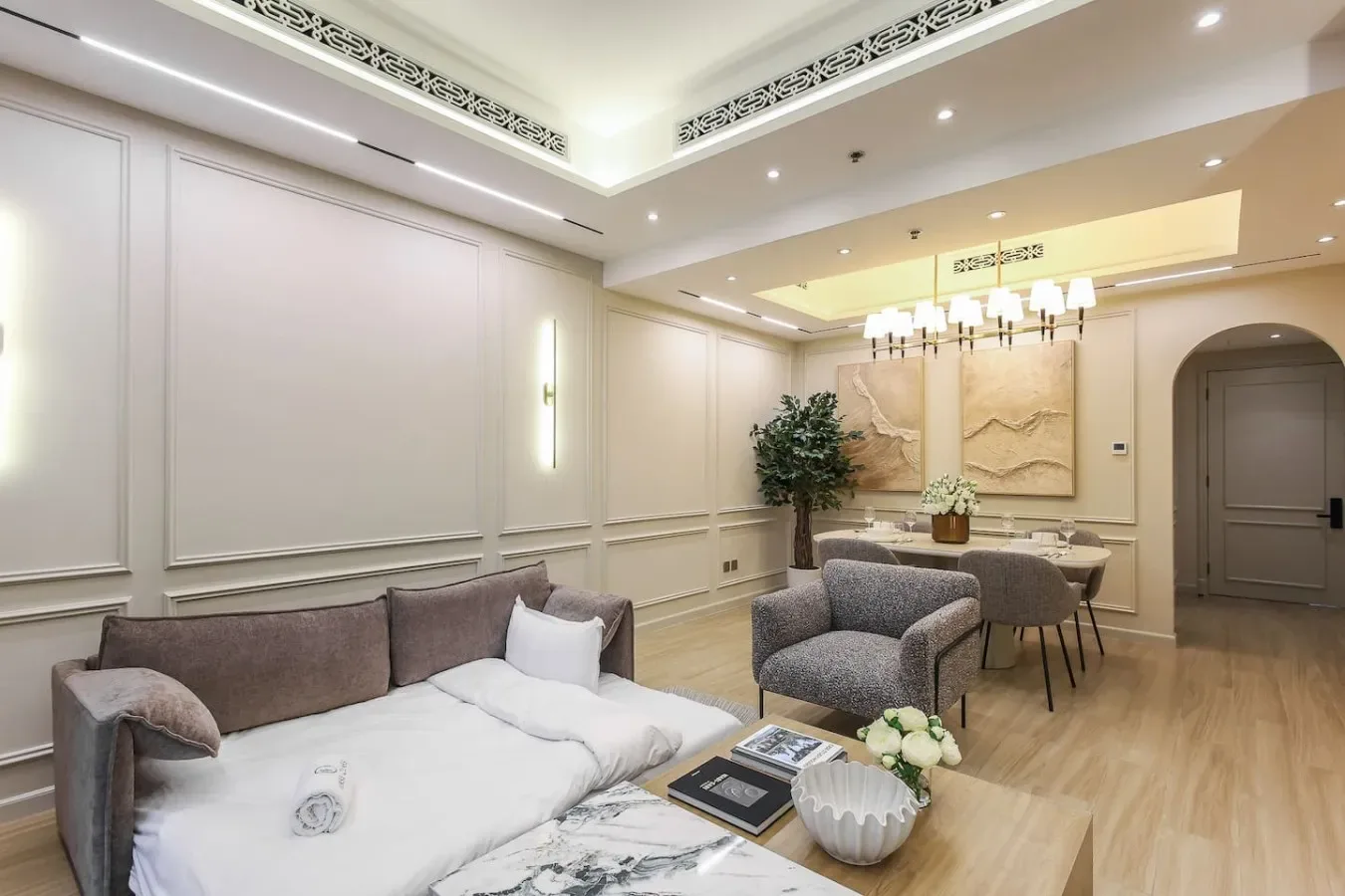 Una sala luminosa con asientos tapizados, una mesa de comedor y paneles decorativos en la pared.
