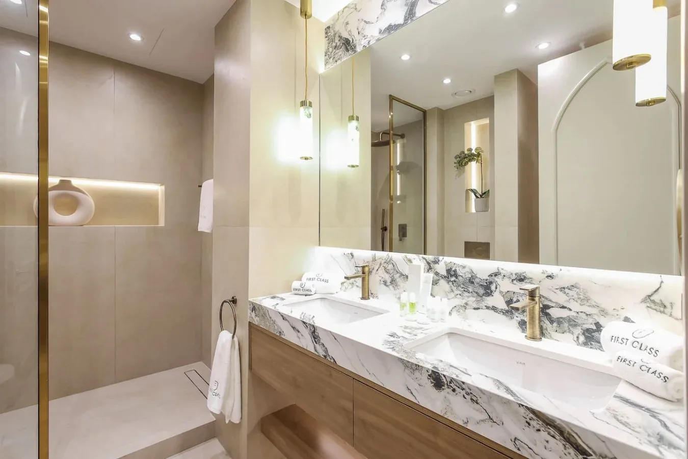 Un baño moderno con un lavabo de mármol y una ducha de cristal.