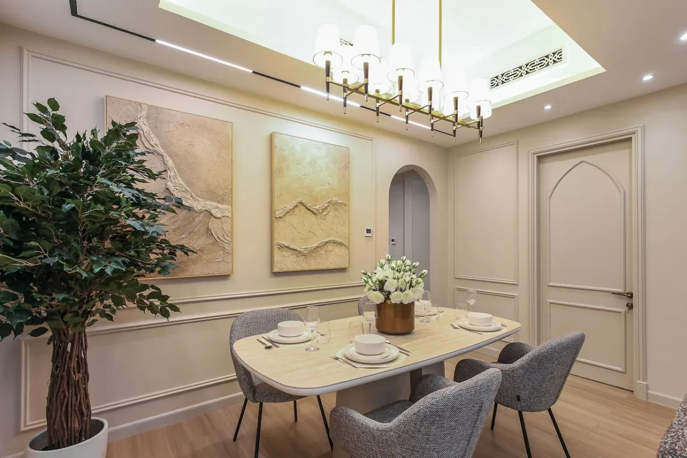 Comedor con una mesa, asientos tapizados y cuadros en la pared.