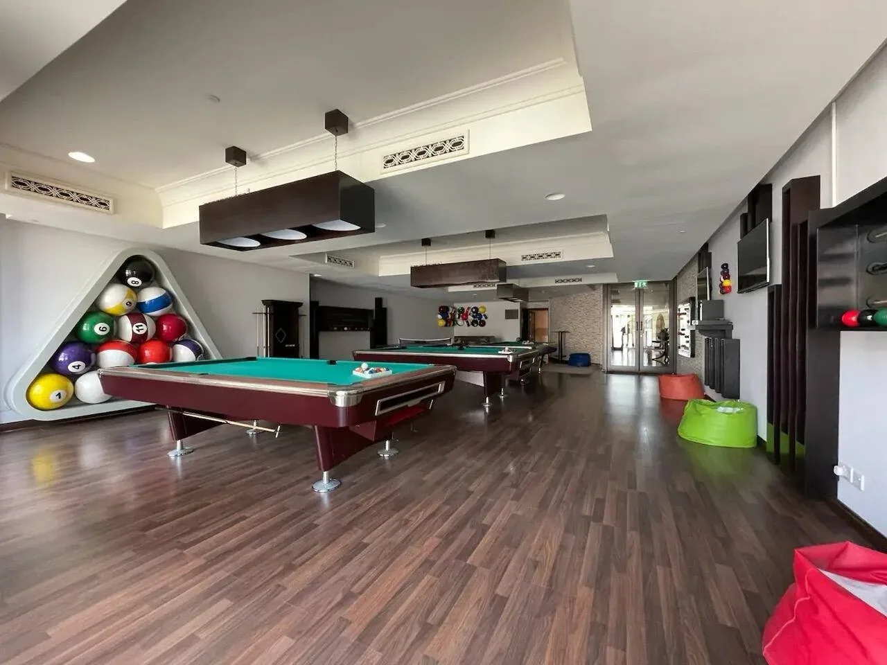 Una sala de recreación con mesas de billar y asientos coloridos.