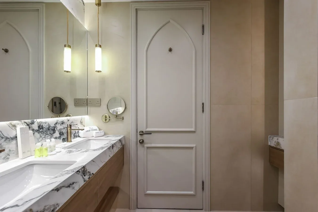 Un lavabo de baño con una encimera de diseño marmolado está junto a una puerta con paneles.