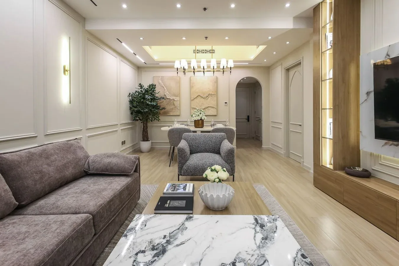 Una sala luminosa con asientos alrededor de una mesa de centro y un televisor.
