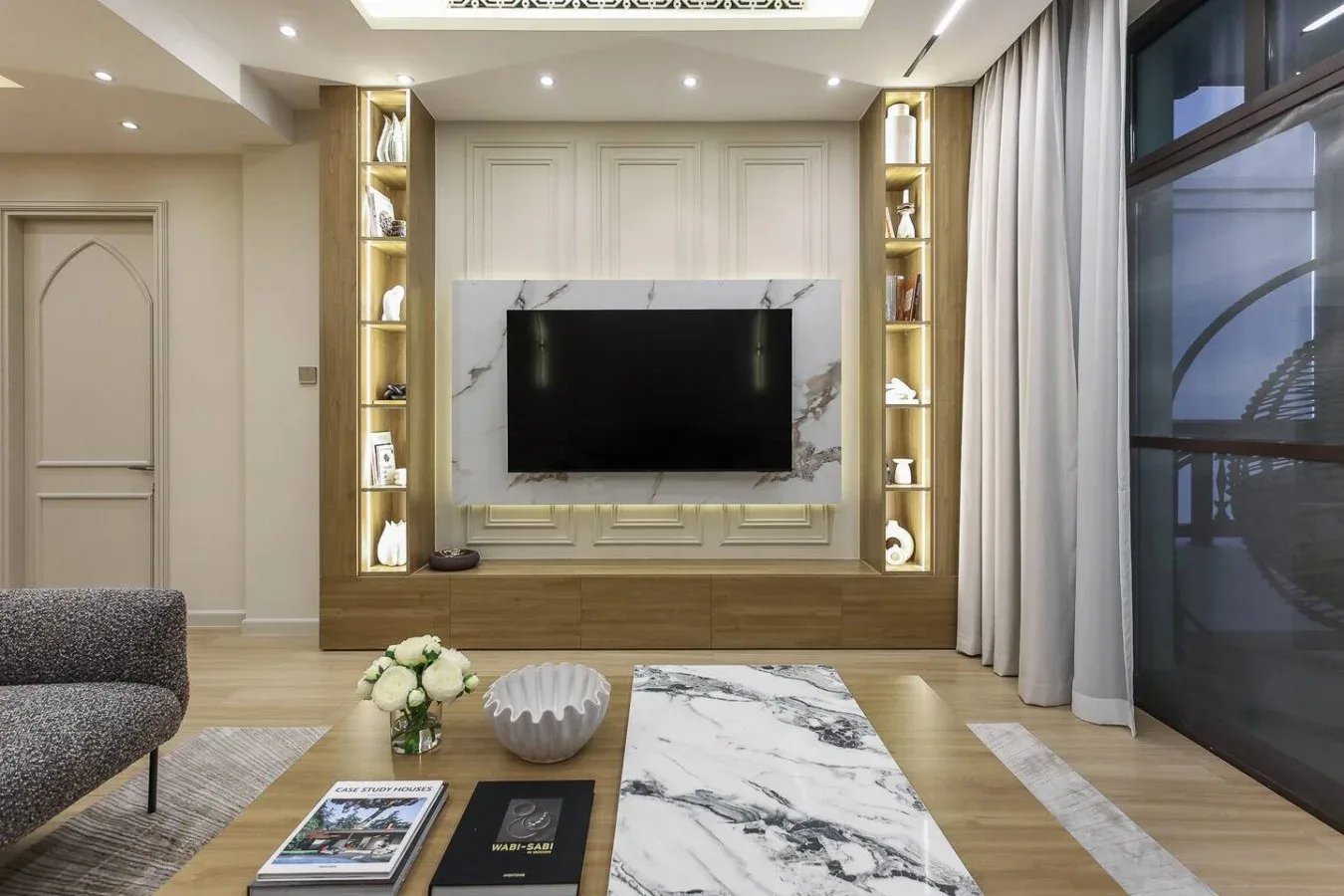 Una sala de estar con un televisor integrado en un mueble decorativo.