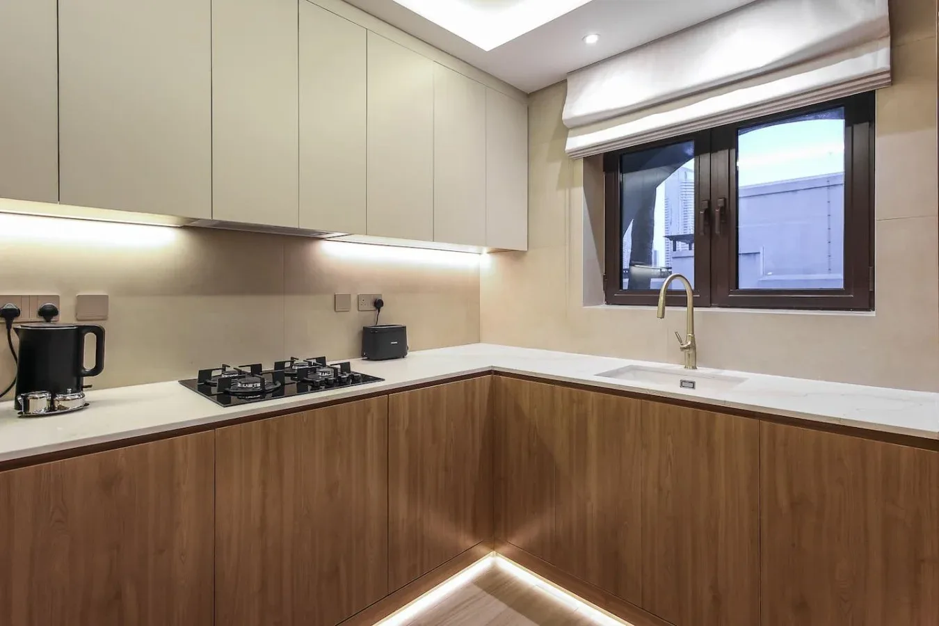 Cocina moderna con gabinetes de madera, una estufa y una ventana sobre el fregadero.