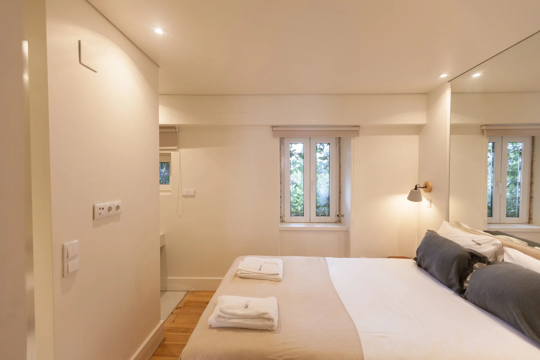 Un dormitorio con una cama bien hecha y una ventana.