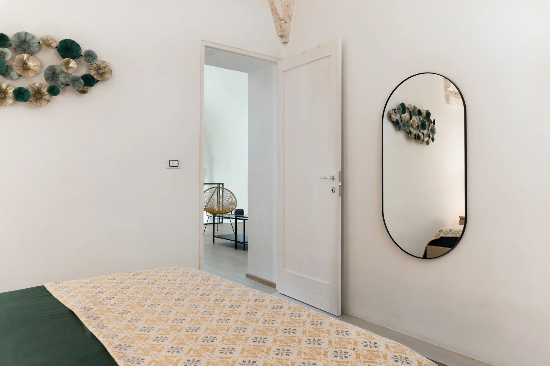 Un dormitorio con una colcha estampada y una puerta abierta.