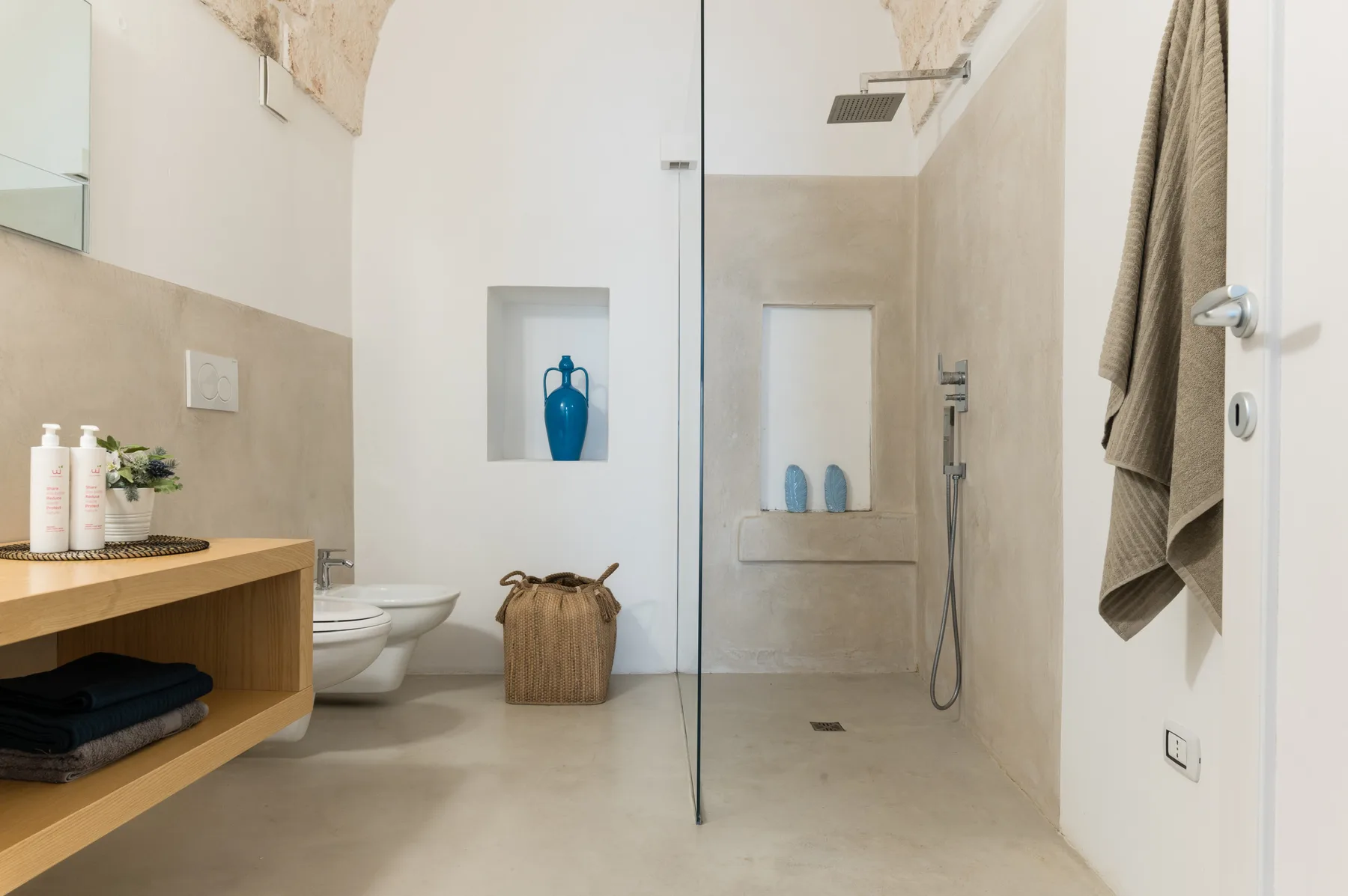 Un baño moderno con ducha a ras de suelo y un mueble de madera.