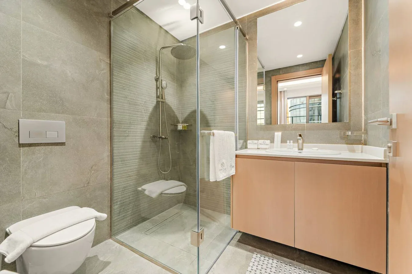 Un baño moderno con una ducha de vidrio y un tocador.
