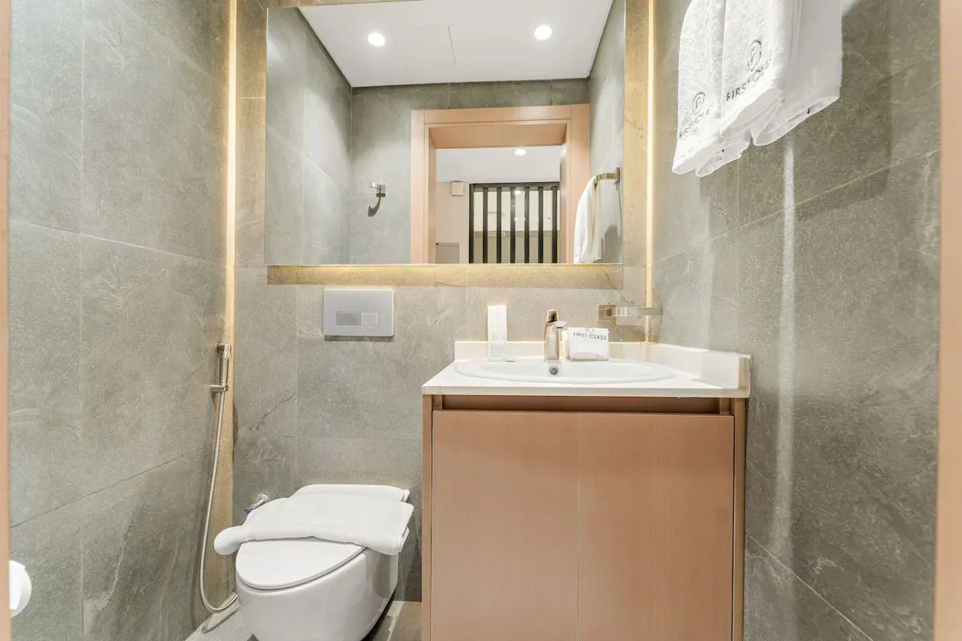 Un baño con azulejos, lavabo, espejo e inodoro.