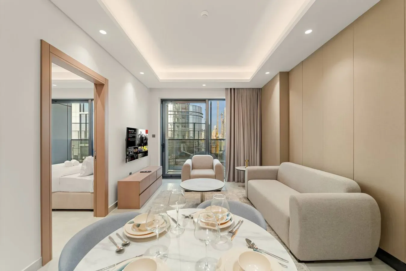 Una sala de estar moderna con asientos de tonos claros y una ventana amplia.