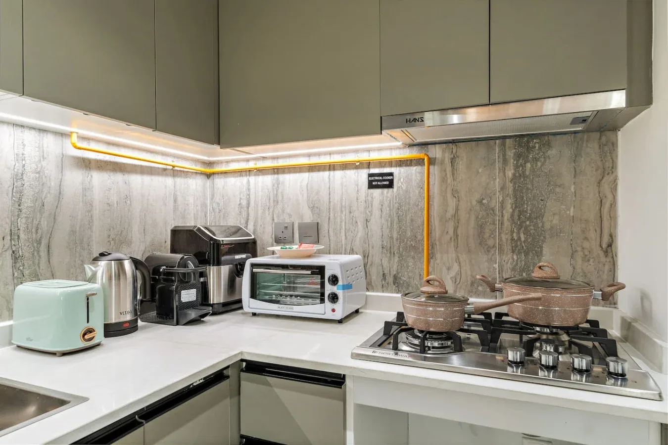 Una cocina moderna con electrodomésticos sobre la encimera y una cocina de gas.