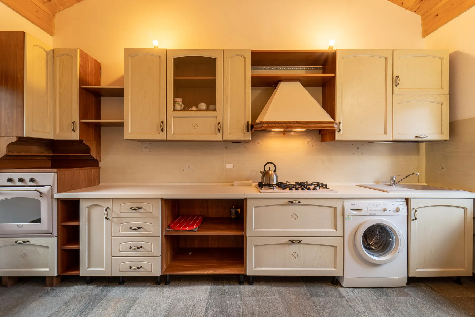 A kitchen with cream cabinets, a countertop, and built-in appliances.
