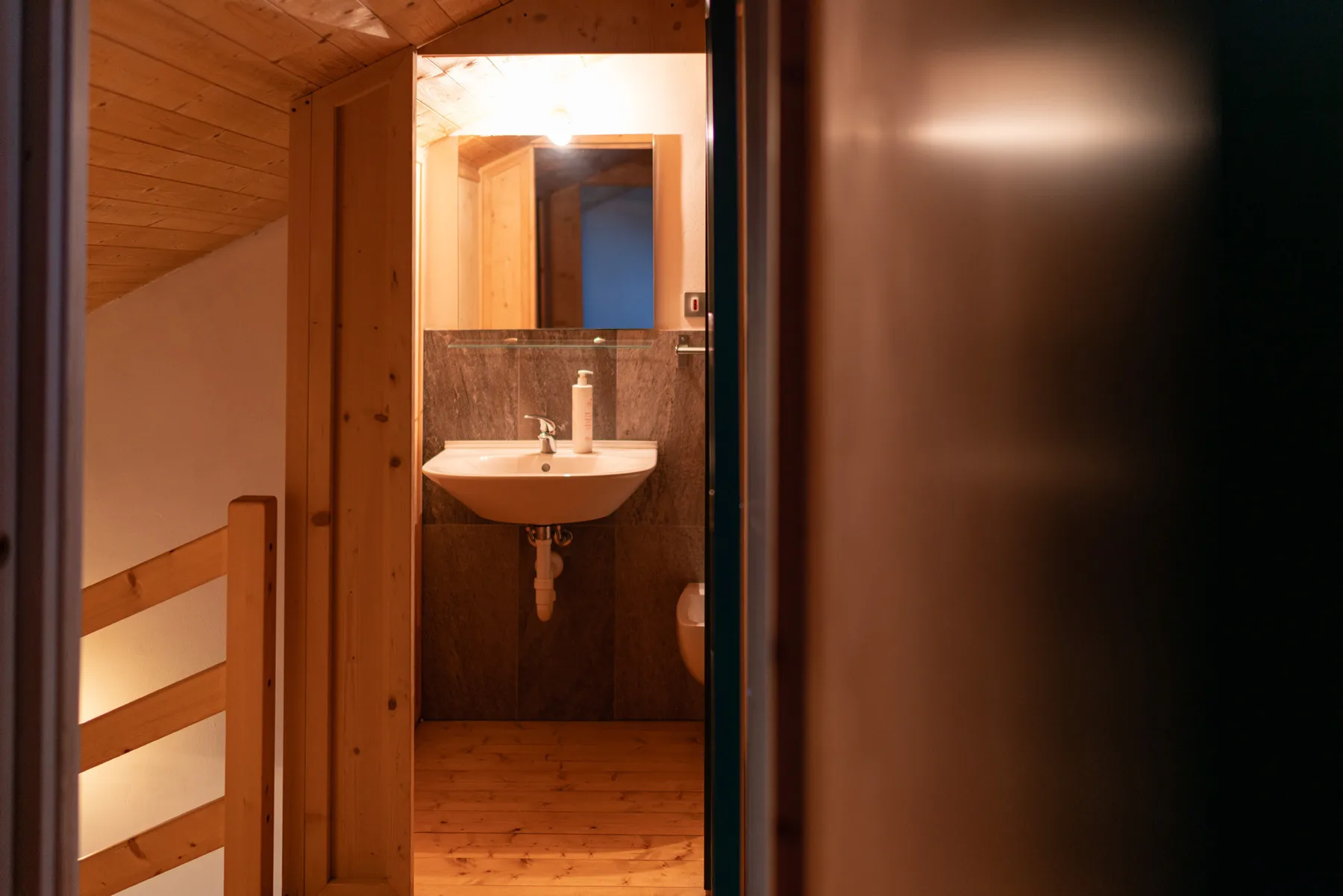 A bathroom vanity is visible beyond a wooden doorway.