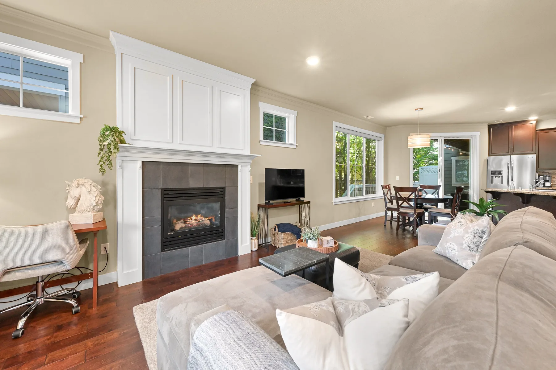 Living room with a fireplace, seating, and an adjoining dining area.