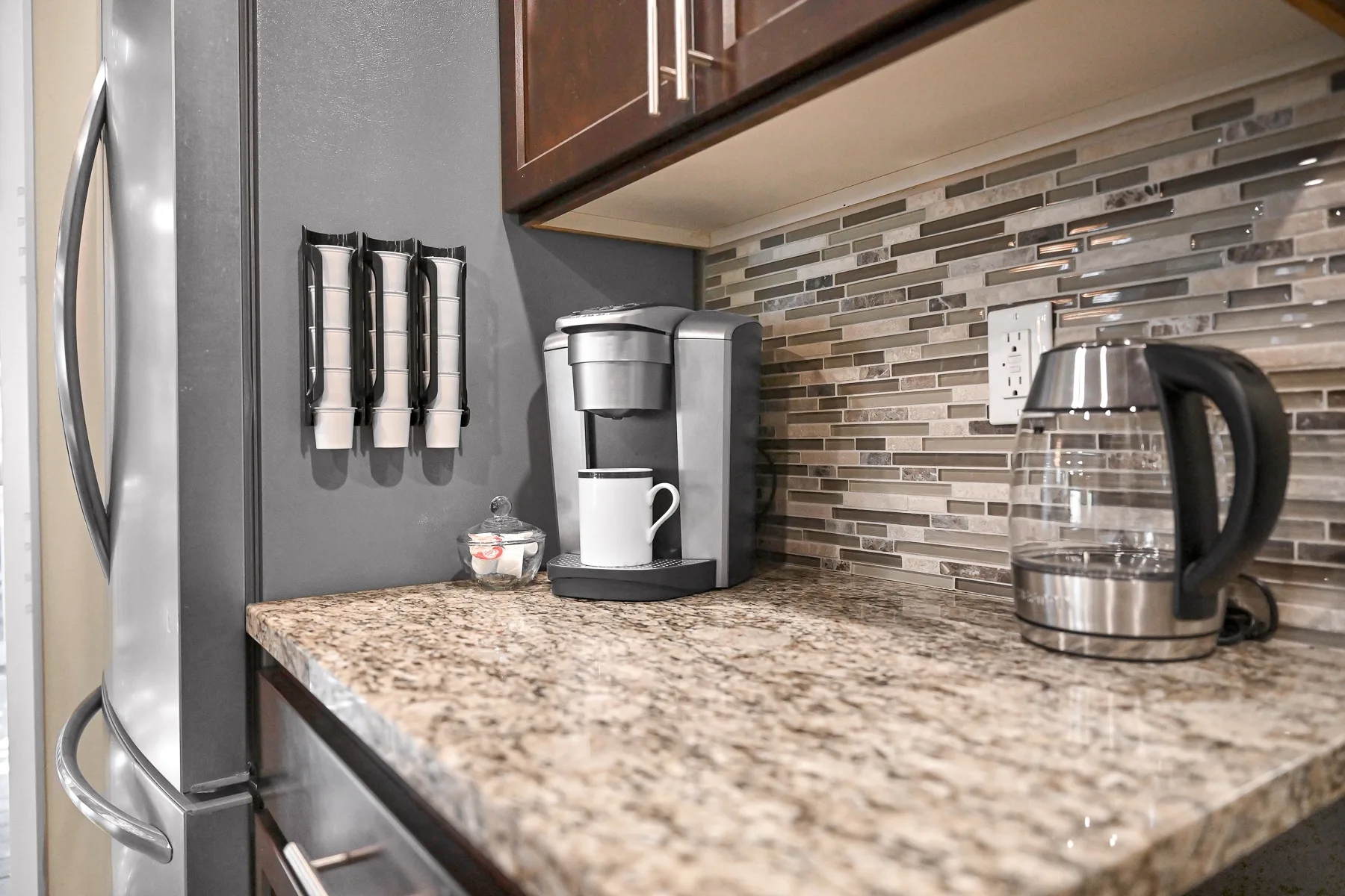 A kitchen counter with a coffee maker and electric kettle.