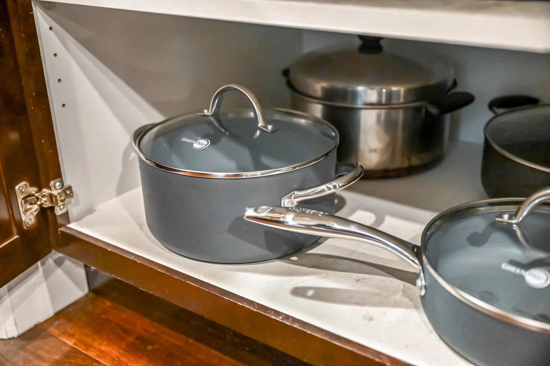 Cookware is arranged on a kitchen stovetop, with several lidded pots.