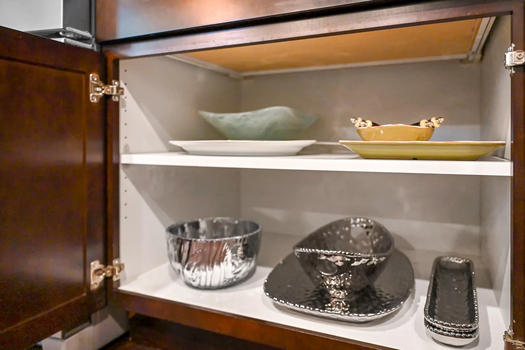 An open display cabinet holds decorative bowls and serving dishes.