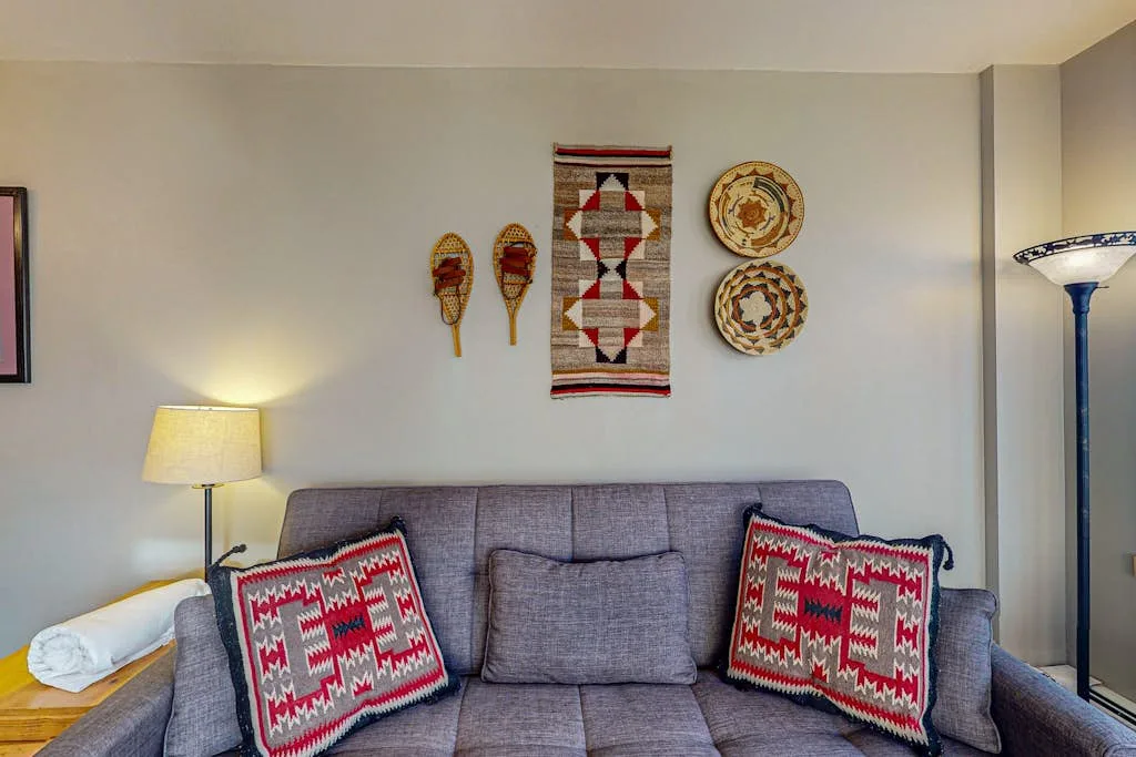 A living room seating area with a gray sofa and patterned cushions.