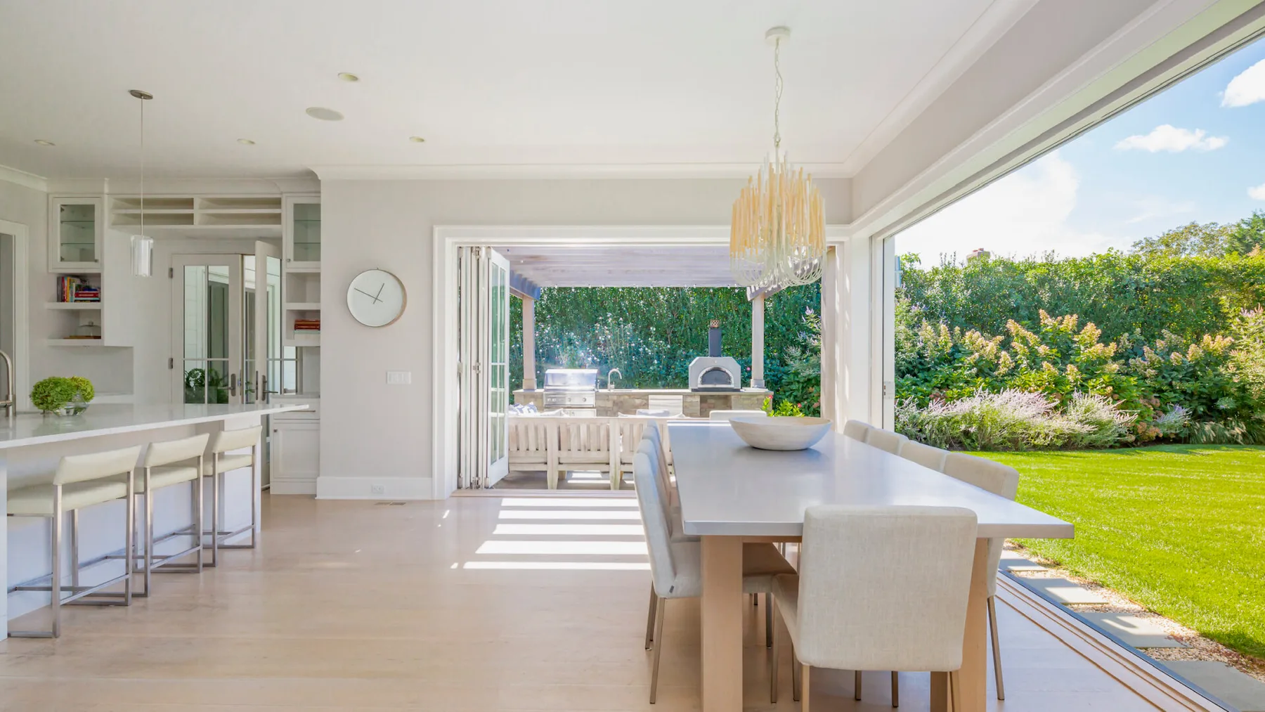 A bright dining area opens onto a patio and green garden.