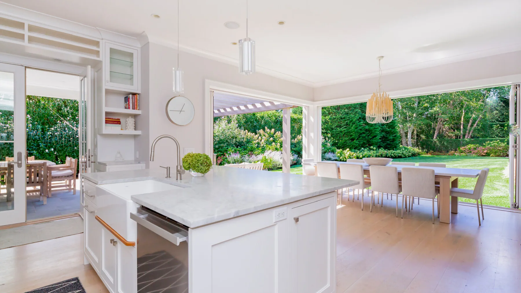 A bright open kitchen and dining area with a large island and garden views.