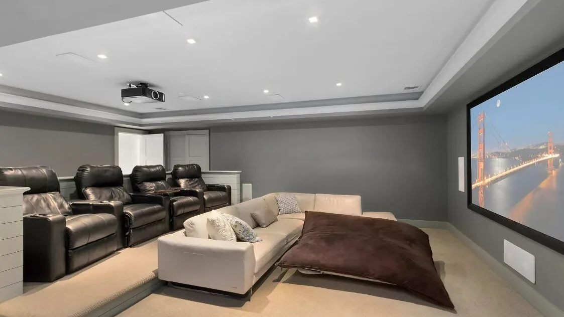 A home theater room with a large screen and rows of seating.