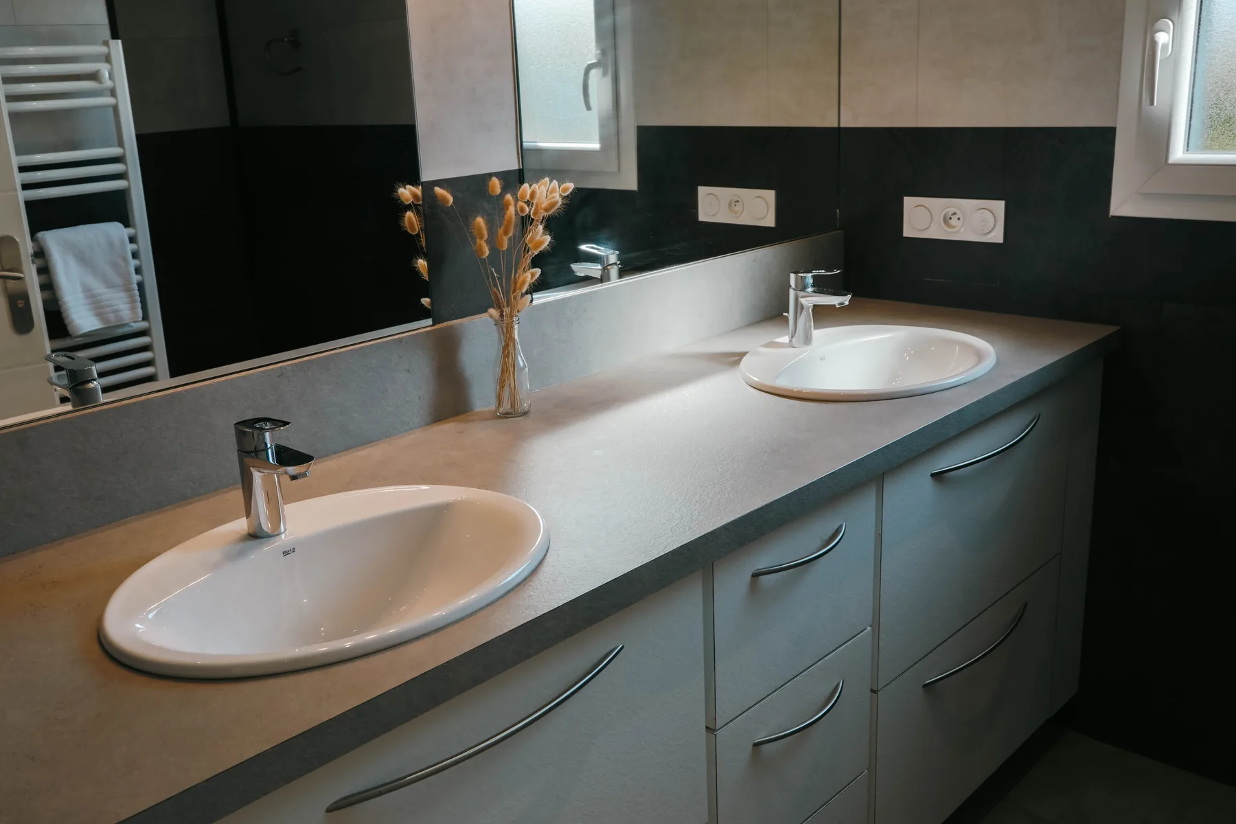 Bathroom with a long vanity, two sinks, and a wall mirror.