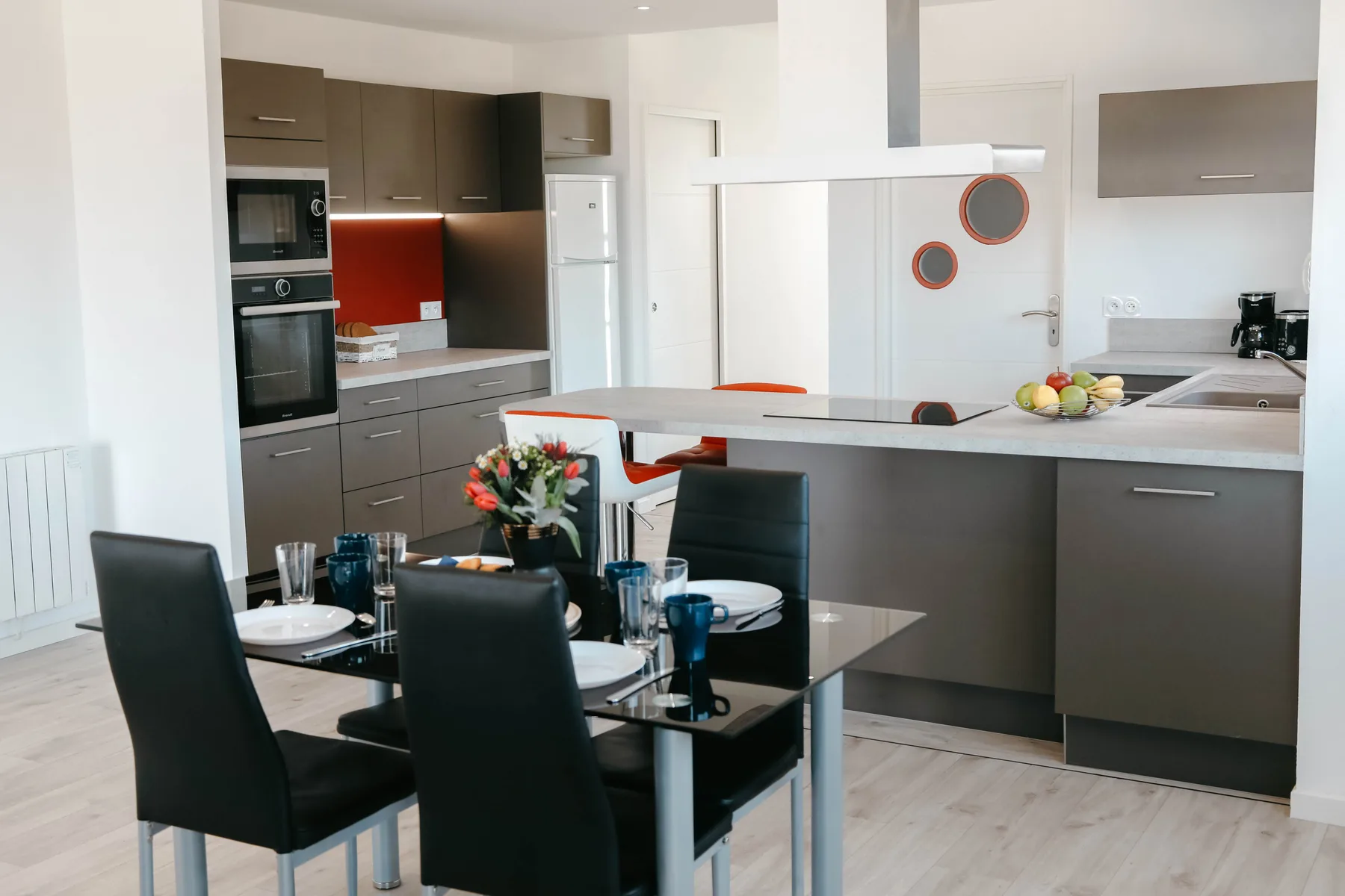 A modern kitchen and dining area with a table set with dishes.