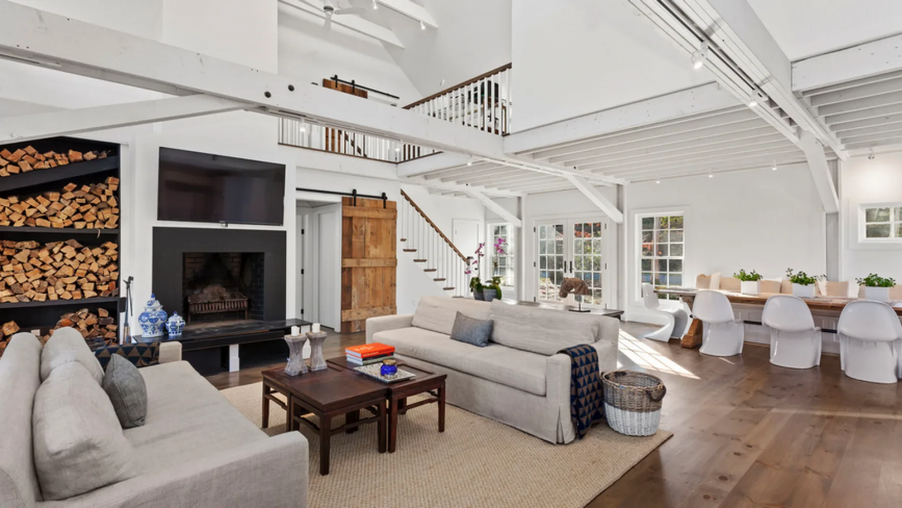 A bright open-plan living room with a fireplace and dining area.