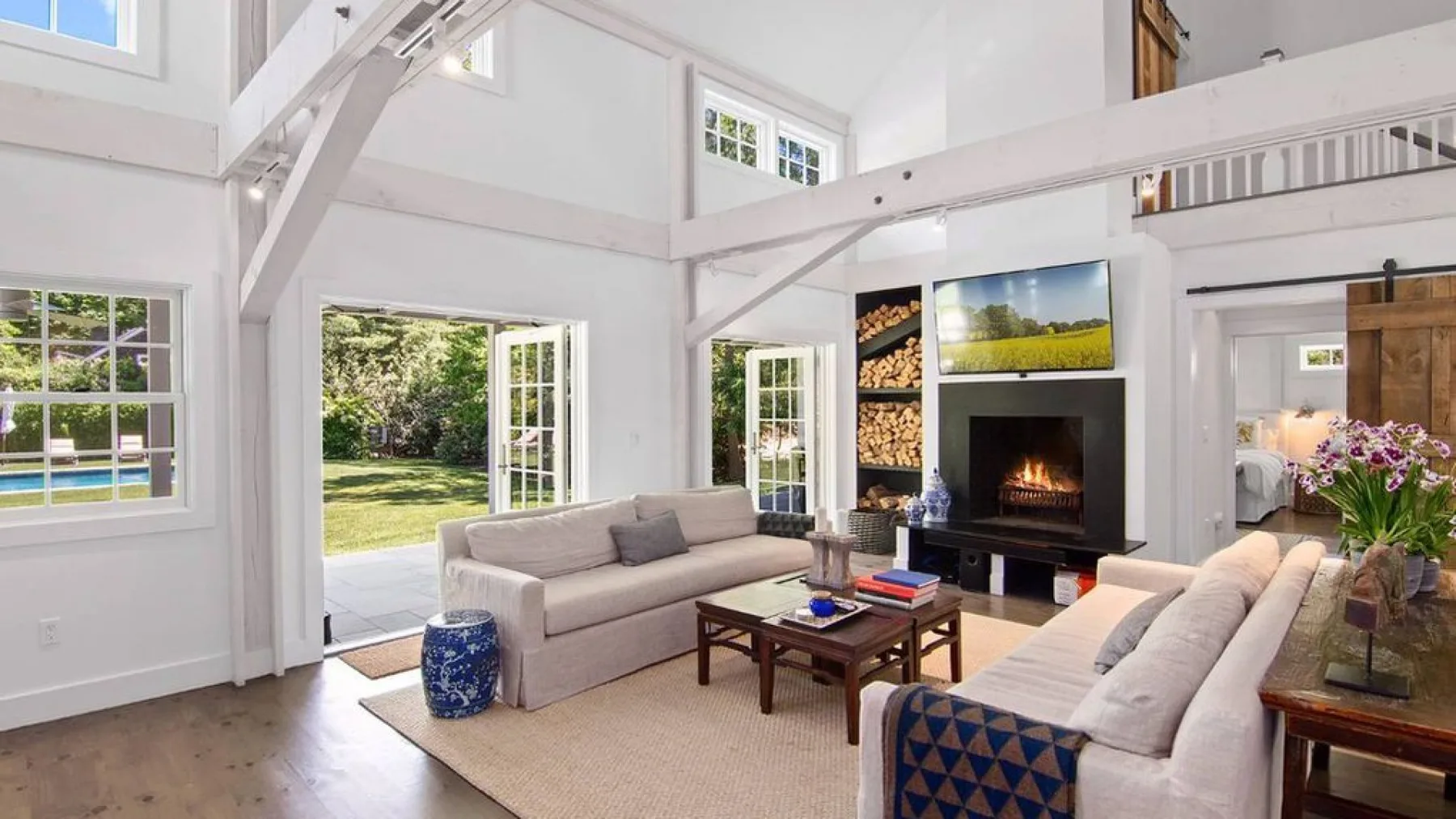 A bright living room with light seating, a coffee table, and a fireplace.