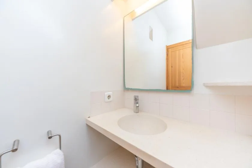 A bright bathroom vanity with a wide mirror and a white sink.