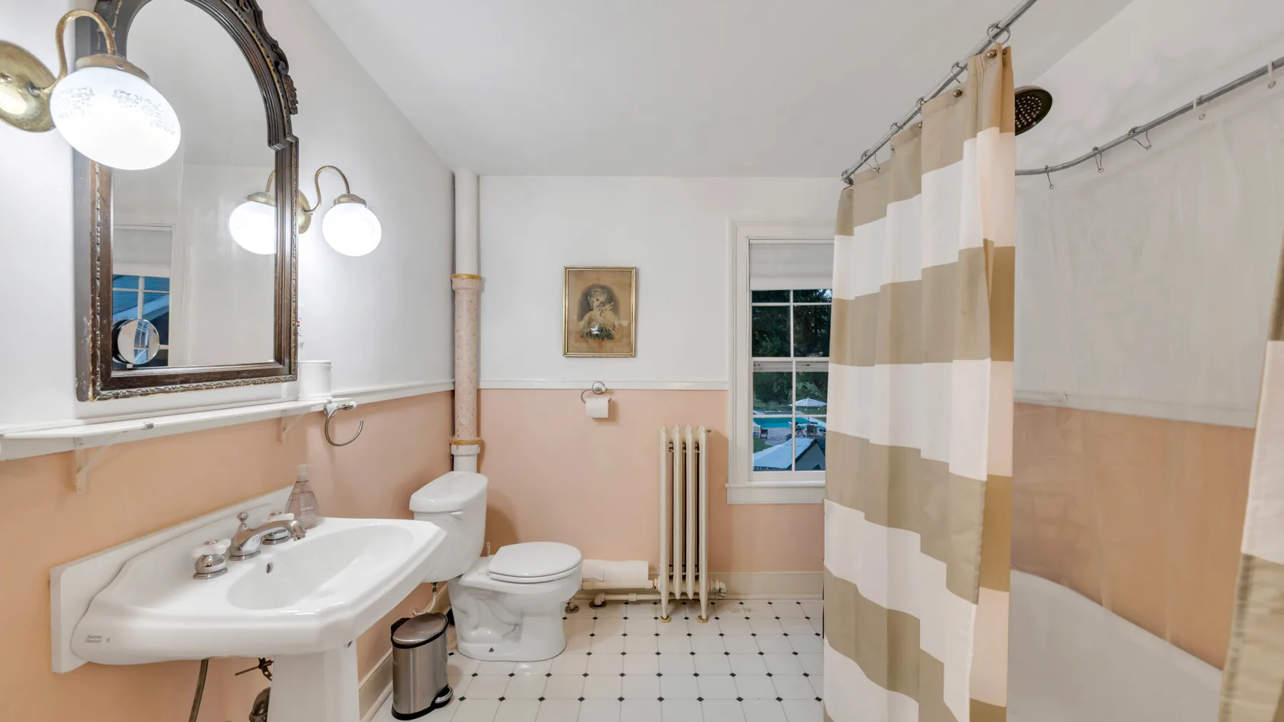 Un baño con lavabo, inodoro y cortina de ducha a rayas.