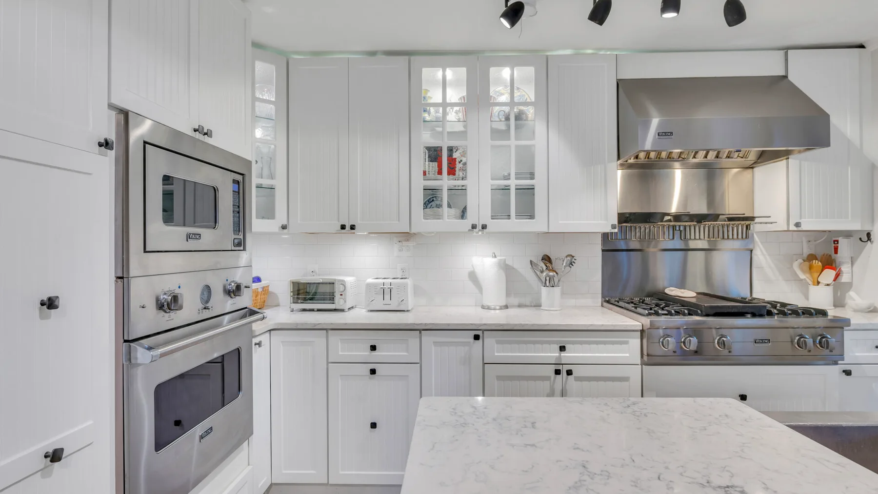 Una cocina luminosa con gabinetes blancos y una gran isla central.